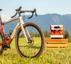 bicycle on grass with espresso machine in background mountains and sky behind it